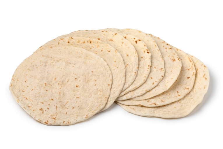 Heap of fresh baked tortilla close up isolated on white background